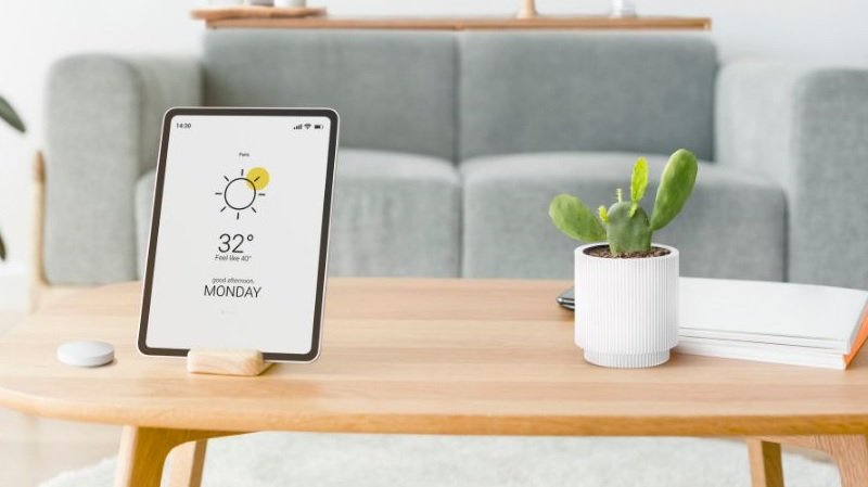 Common Smart Home Automation Mistakes to Avoid - a smart ipad with a flowerpot on table with notepad and sofa in background