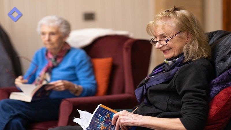 The Benefits of Smart Home for Aging in Place - pic of 2 elderly ladies reading book